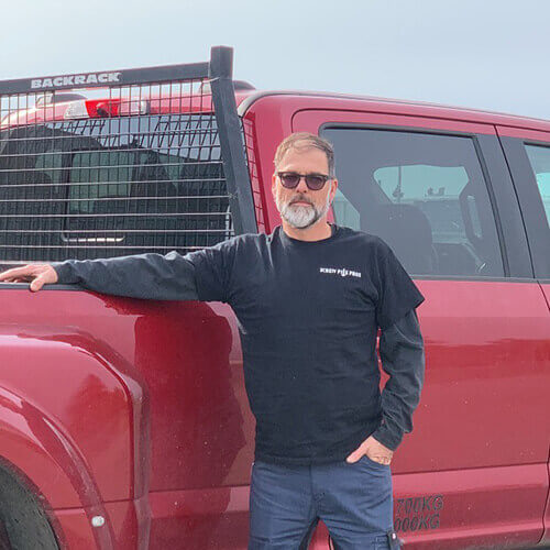 Screw Pile Pros Inc founder Mat, poses in front of truck